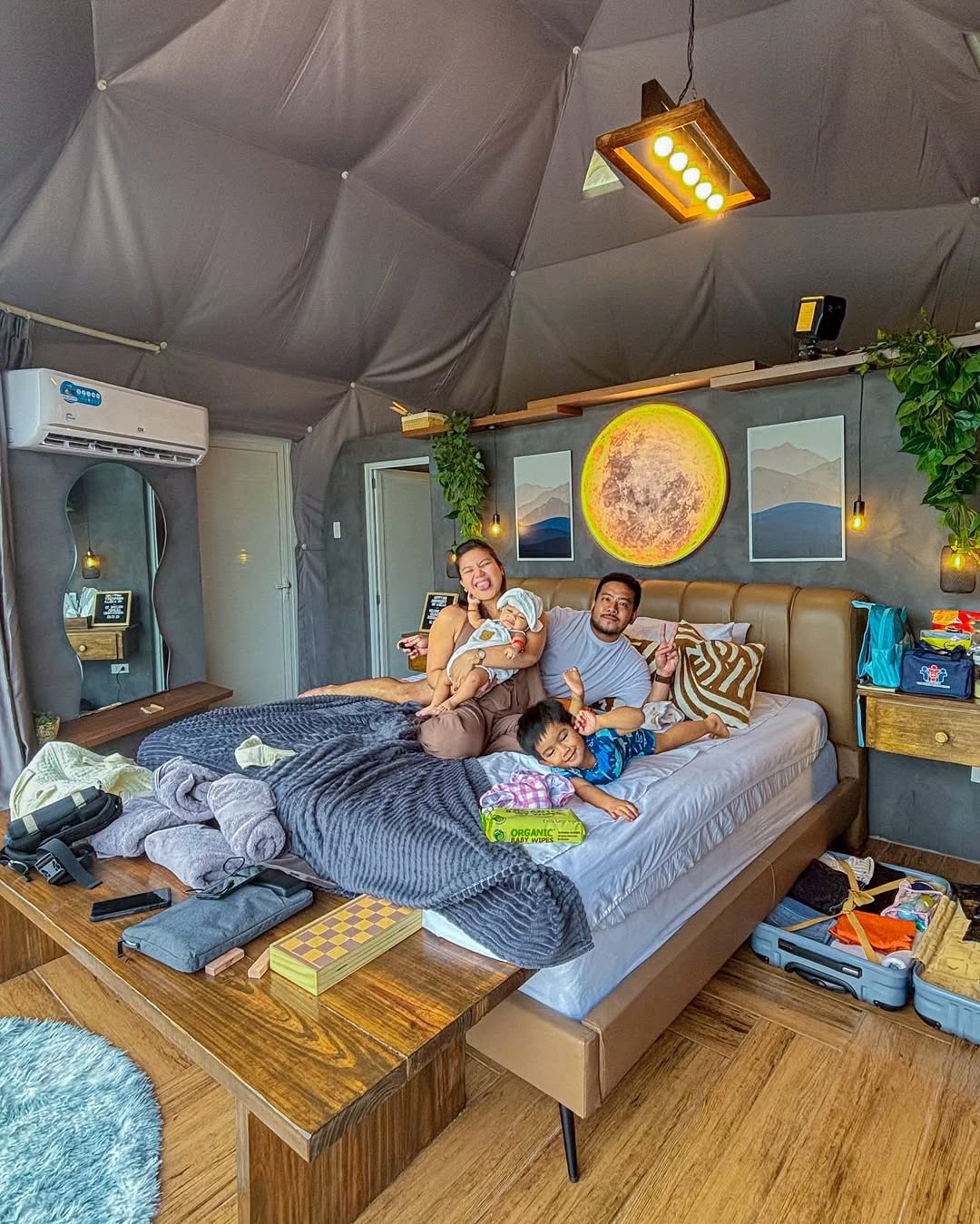 The Luna Suite interior — family on the king bed, dome ceiling